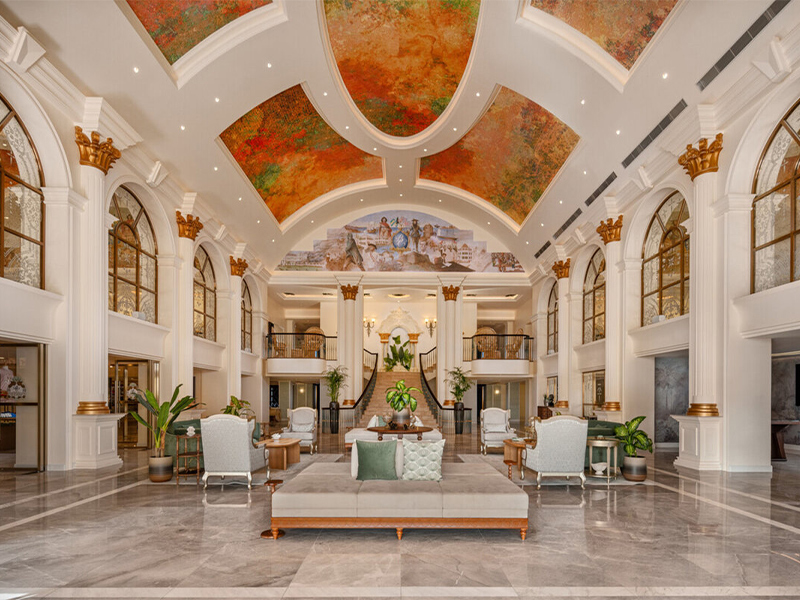 Large hotel lobby with marble floors and ceiling murals