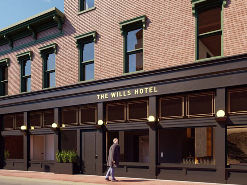 a man walking in front of a hotel